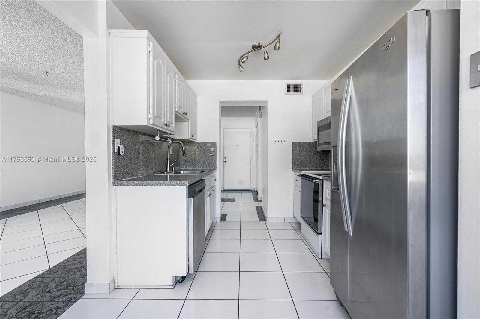 7300 Wayne Avenue, Unit 317 Miami Beach, FL 33141 - Photo 9 of 26 a kitchen with a refrigerator and a sink