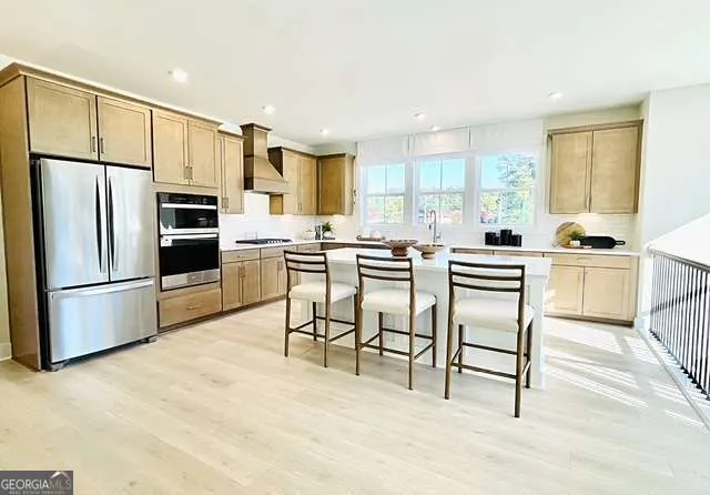 a kitchen with stainless steel appliances a stove a sink cabinets and a refrigerator