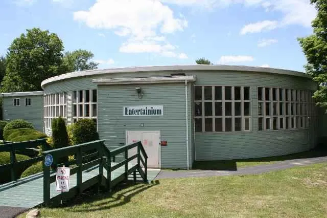 a view of a small house with wooden fence