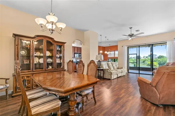 a dining room with furniture a chandelier and wooden floor