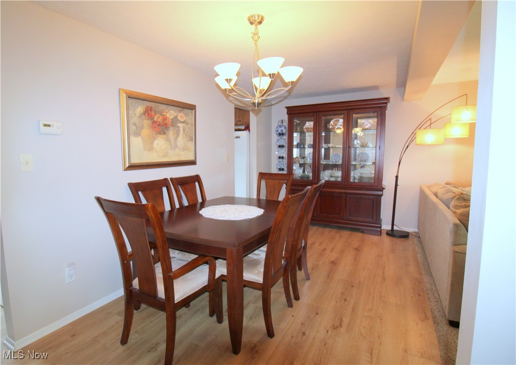 6478 State Road, Unit G8 Cleveland, OH 44134 - Photo 11 of 36 Dining Room with LTV Flooring, Modern Neutral Paint and Light Fixture Open to Living Room