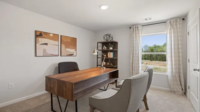 a view of a dry field with trees in the background