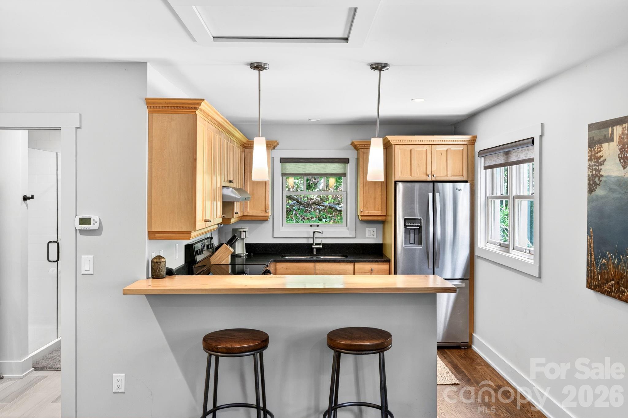 235 Bull Creek Road Asheville, NC 28805 - Photo 38 of 47 a kitchen with a table chairs refrigerator and window
