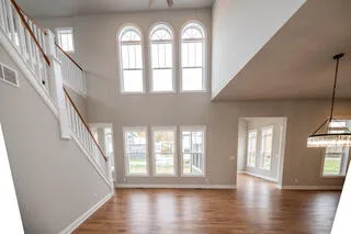 a living room with furniture a mirror and a view of kitchen