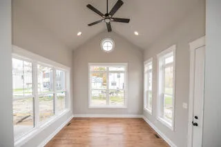 a kitchen with stainless steel appliances granite countertop a refrigerator a stove a sink a dining table and chairs with wooden floor