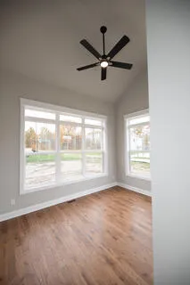 a spacious bedroom with a bed painting on wall and a flat screen tv