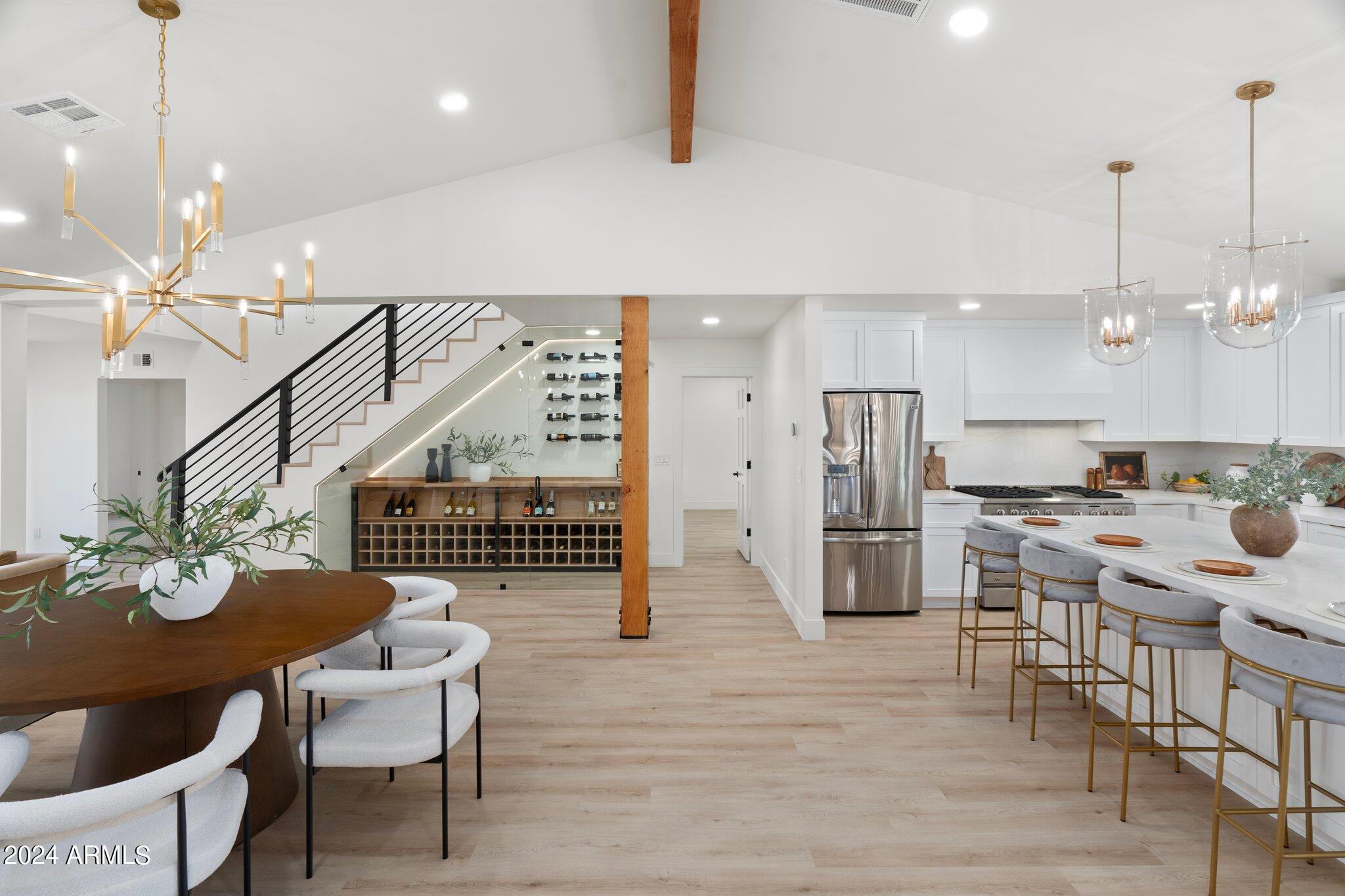 a kitchen with stainless steel appliances kitchen island granite countertop a table chairs and a refrigerator