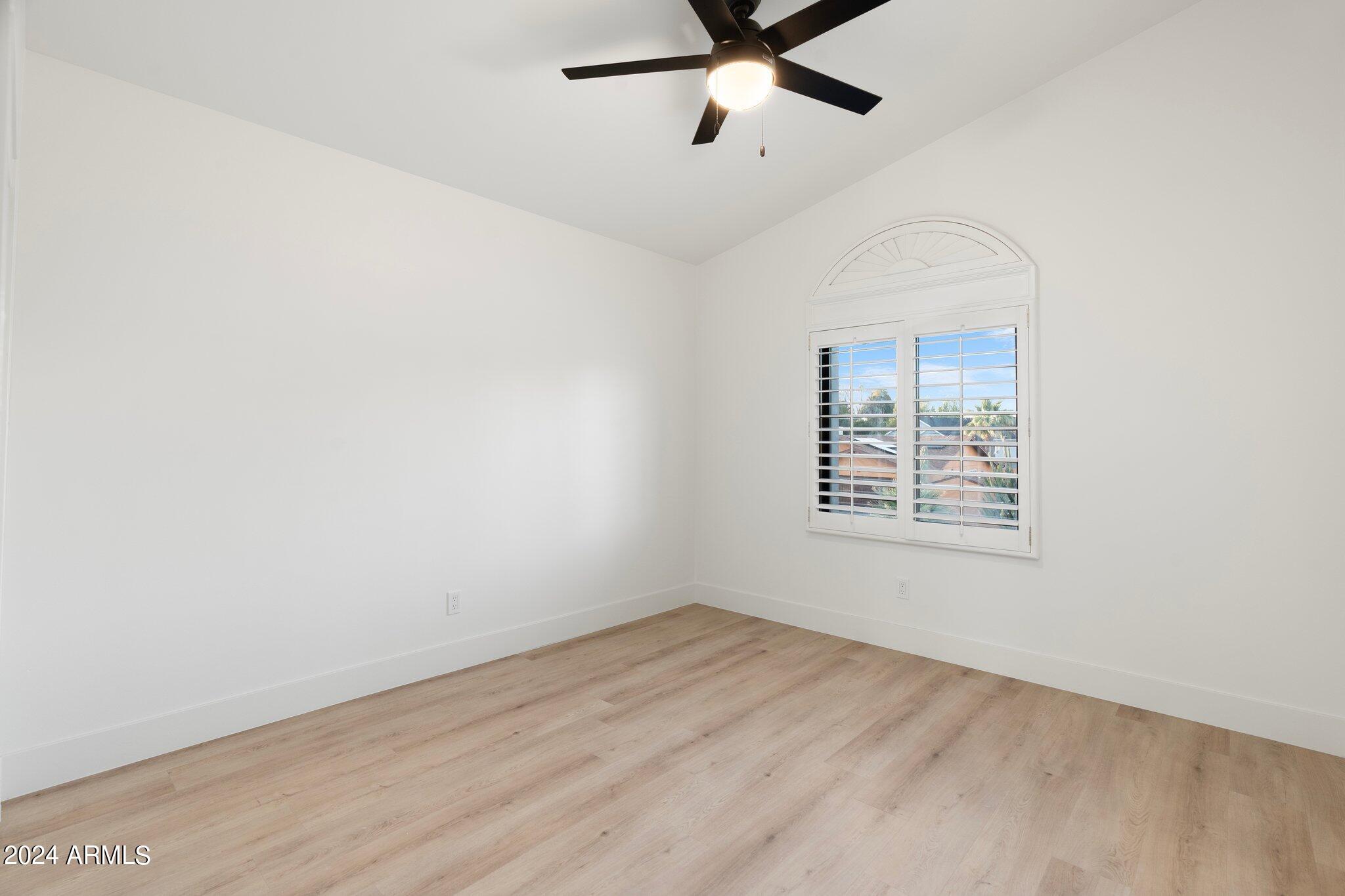 1643 West Griswold Road Phoenix, AZ 85021 - Photo 15 of 81 an empty room with wooden floor fan and windows