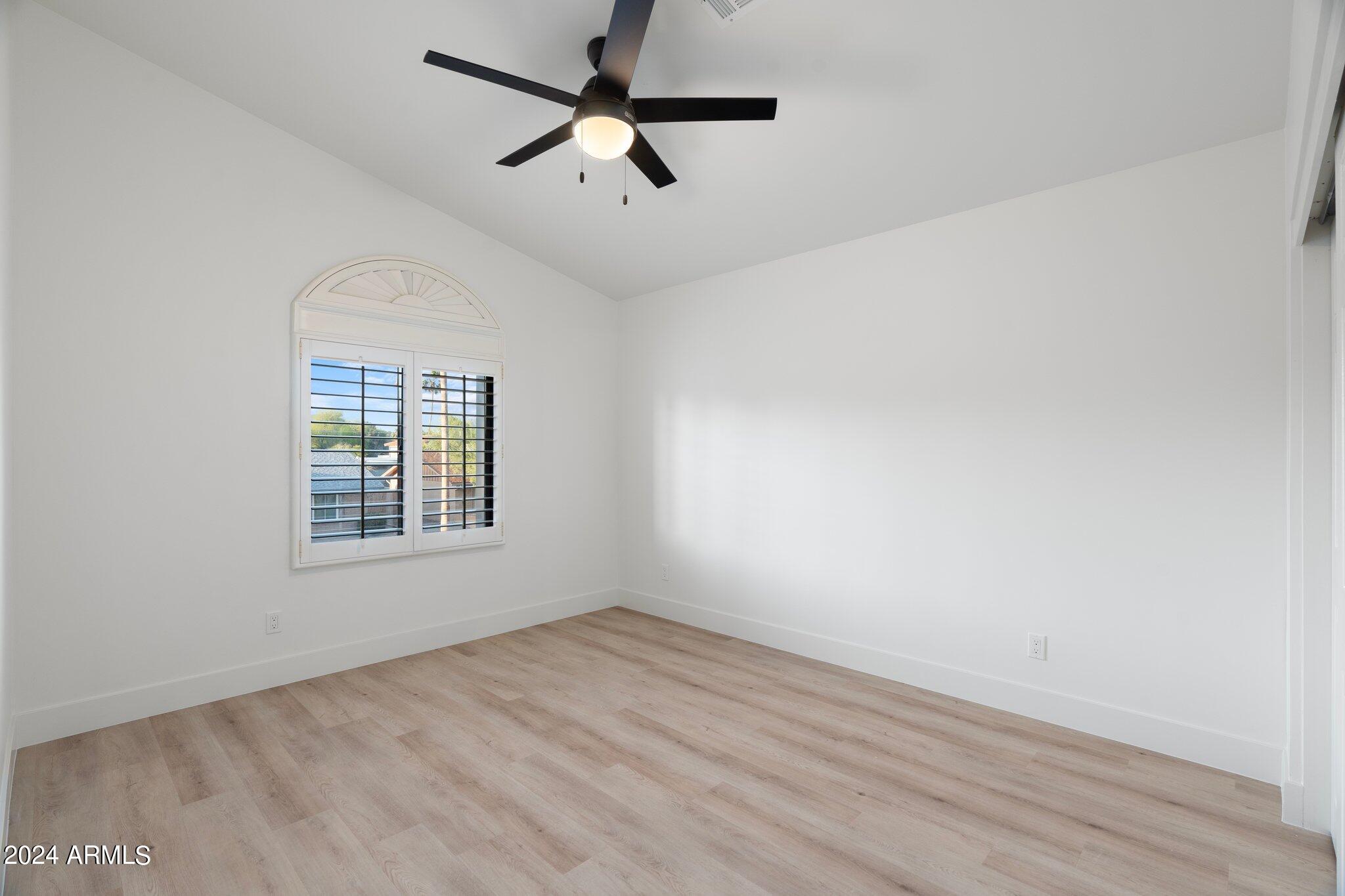 1643 West Griswold Road Phoenix, AZ 85021 - Photo 16 of 81 an empty room with wooden floor ceiling fan and windows