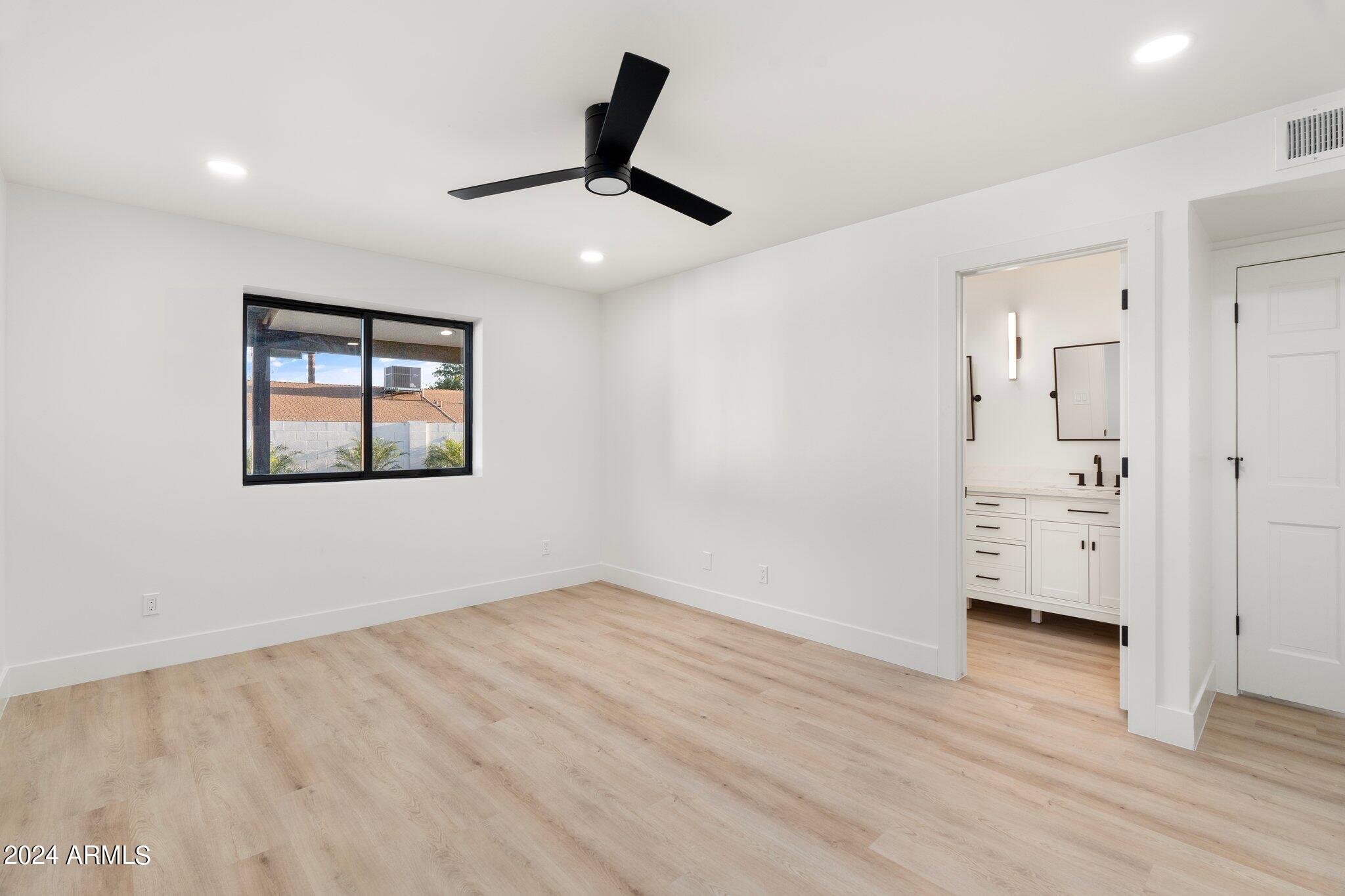 1643 West Griswold Road Phoenix, AZ 85021 - Photo 22 of 81 an empty room with wooden floor cabinet and windows