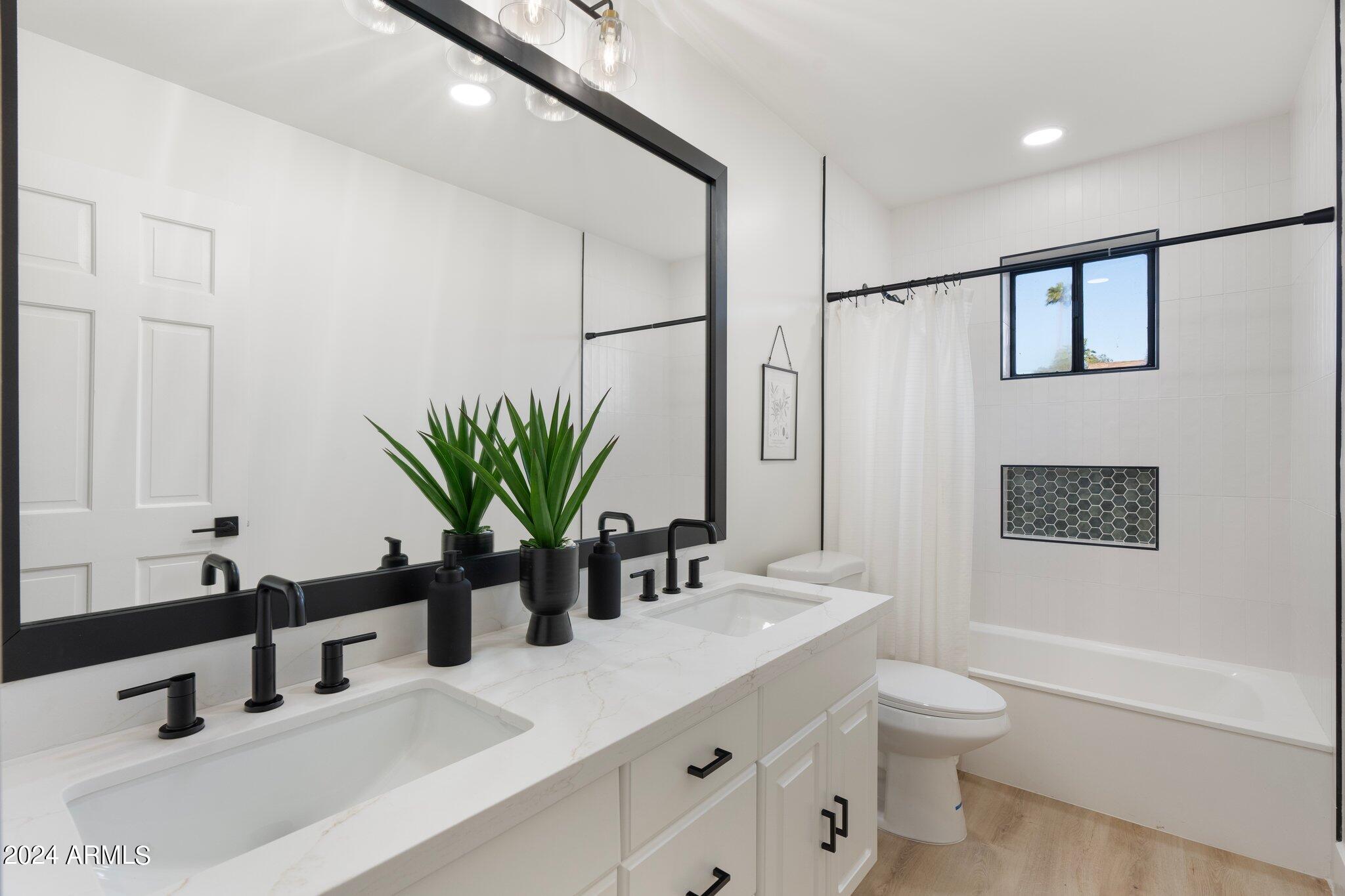 1643 West Griswold Road Phoenix, AZ 85021 - Photo 28 of 81 a bathroom with a double vanity sink a toilet and a tub
