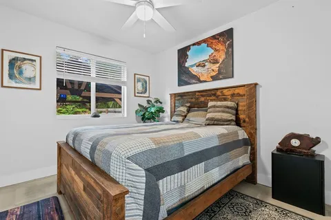 a bedroom with a bed and a painting on the wall