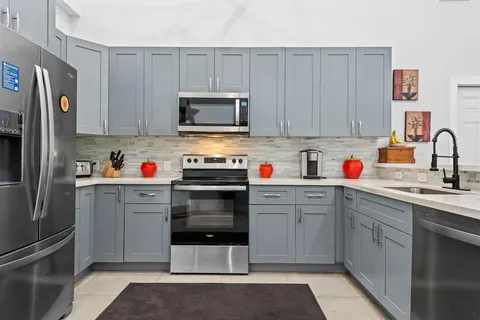 a kitchen with stainless steel appliances granite countertop a refrigerator stove and sink