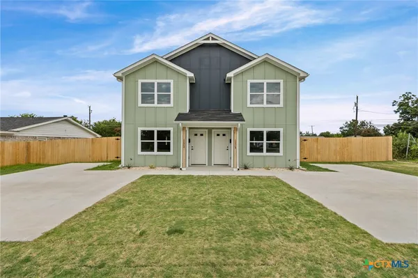a front view of a house with a garden and garage