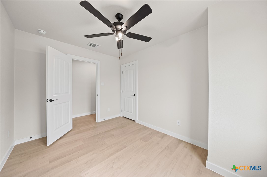 1204 Martin Luther King Jr Lane, Unit A Temple, TX 76504 - Photo 14 of 21 an empty room with a ceiling fan and a ceiling fan