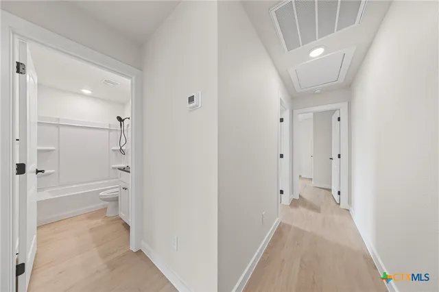 a bathroom with a granite countertop sink a toilet a mirror and shower