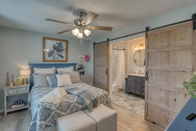 a bedroom with a large bed and a chandelier