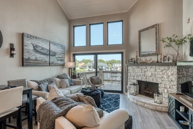 a living room with furniture a fireplace and a floor to ceiling window
