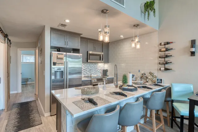 a kitchen with granite countertop a sink and refrigerator