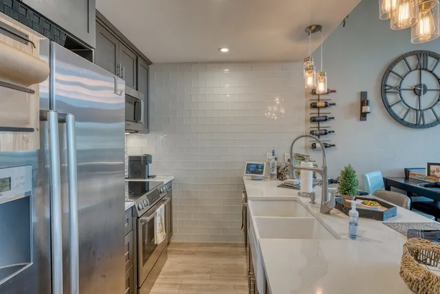 a kitchen with stainless steel appliances a sink a stove and a refrigerator