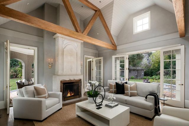 a living room with furniture a fireplace and a large window