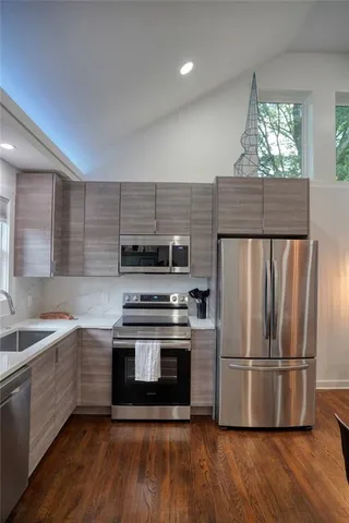 a kitchen with a sink a microwave a refrigerator and cabinets