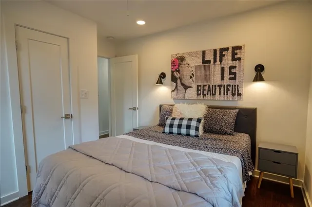 a bedroom with a bed and painting on the wall