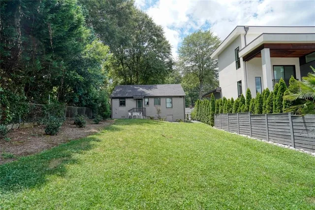 a view of a patio with table and chairs potted plants and a large tree