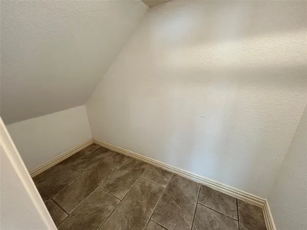 an empty room with wooden floor ceiling fan and windows