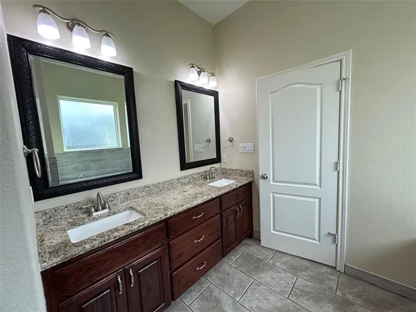 a bathroom with a granite countertop sink and a mirror