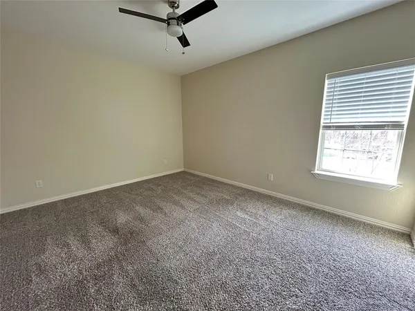 an empty room with windows and fan view