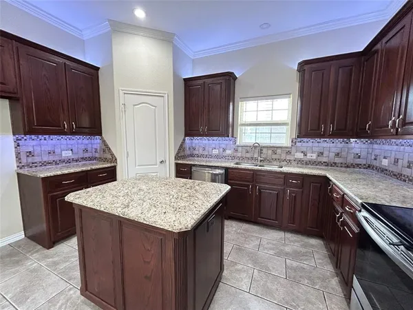 a kitchen with a stove a sink a refrigerator and wooden cabinets