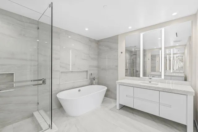 a bathroom with a tub sink shower and mirror