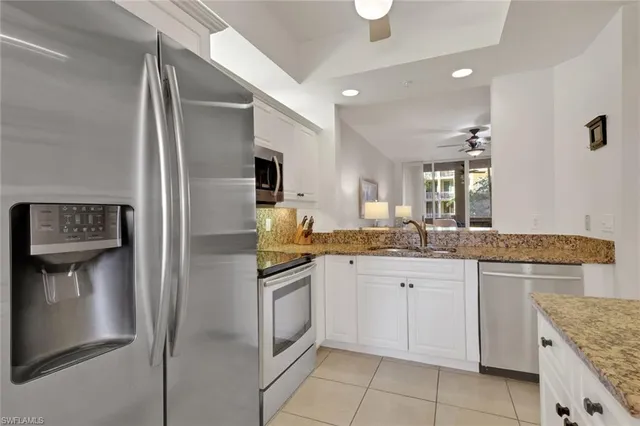 a kitchen with granite countertop a sink stove and refrigerator