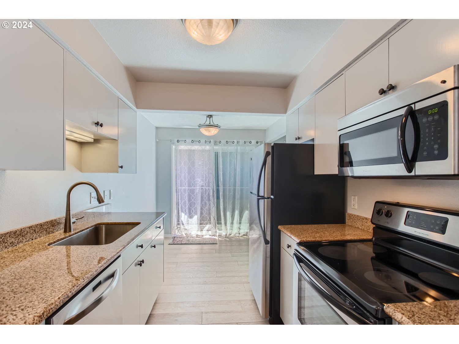 2022 Northeast Clackamas Street Portland, OR 97232 - Photo 7 of 13 a kitchen with stainless steel appliances granite countertop a sink and refrigerator