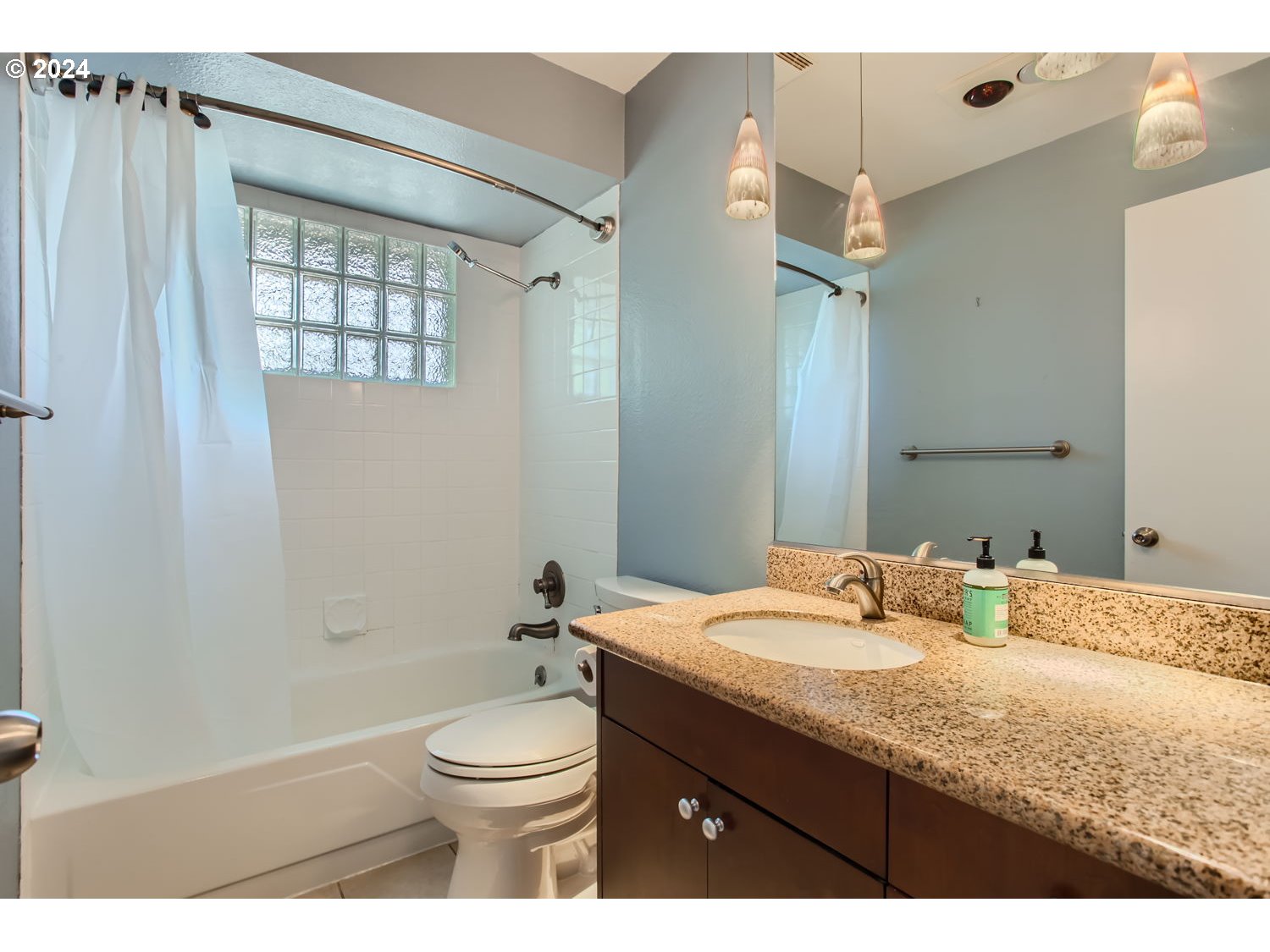2022 Northeast Clackamas Street Portland, OR 97232 - Photo 10 of 13 a bathroom with a granite countertop sink toilet a large mirror and shower
