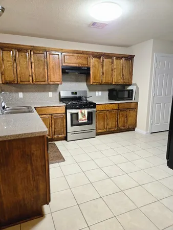 a kitchen with stainless steel appliances a sink stove top oven and cabinets