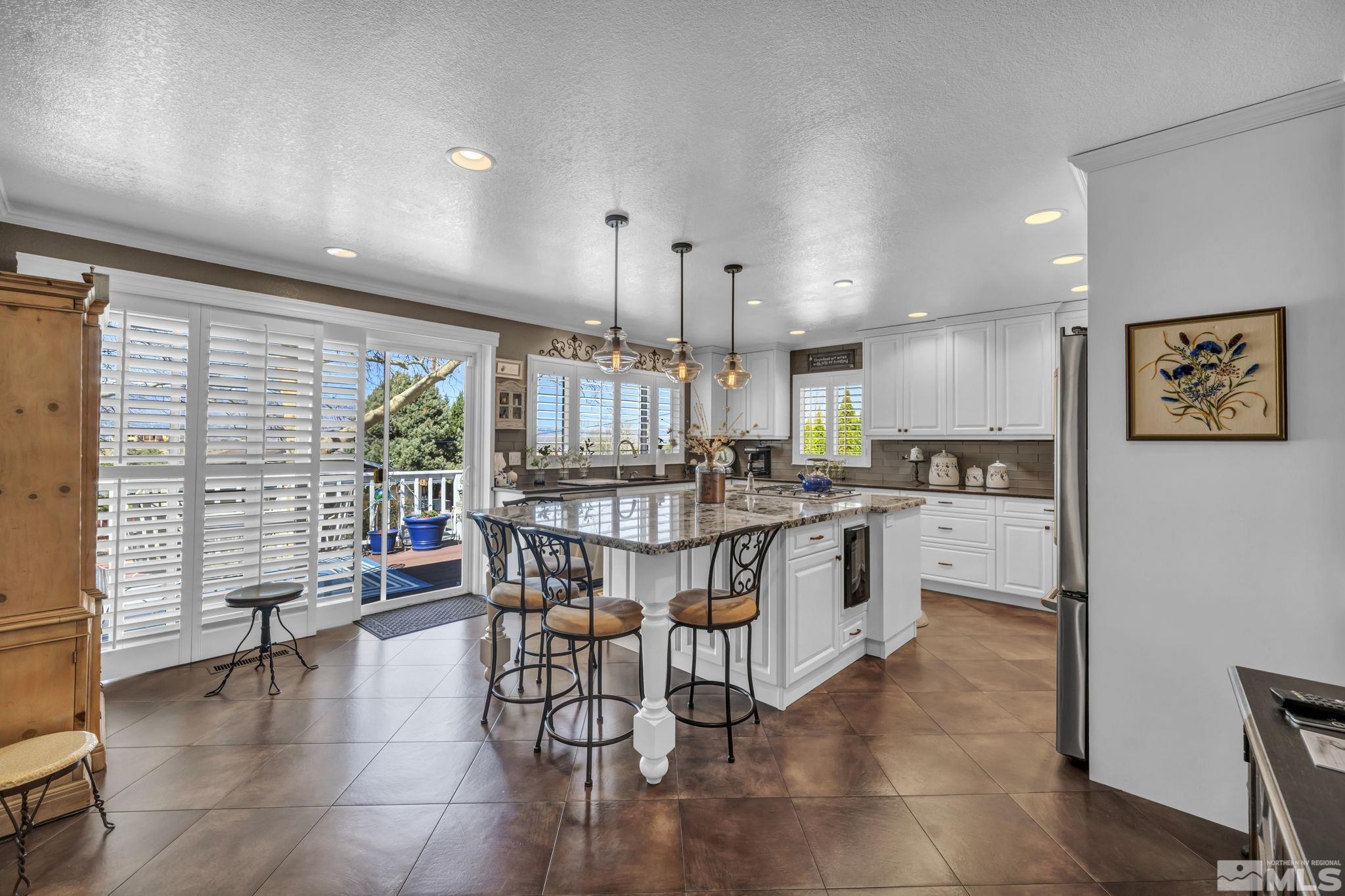 14435 Virginia Foothills Drive Reno, NV 89521 - Photo 14 of 40 a kitchen with a table chairs wooden floors and a view of living room