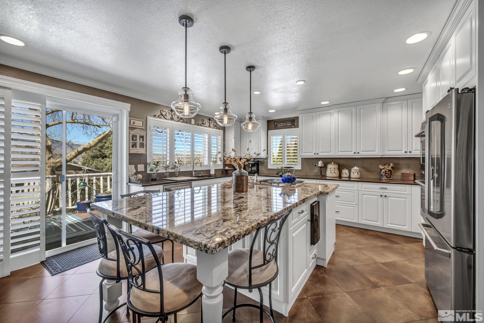 14435 Virginia Foothills Drive Reno, NV 89521 - Photo 17 of 40 a kitchen with stainless steel appliances granite countertop a kitchen island a stove a table and chairs
