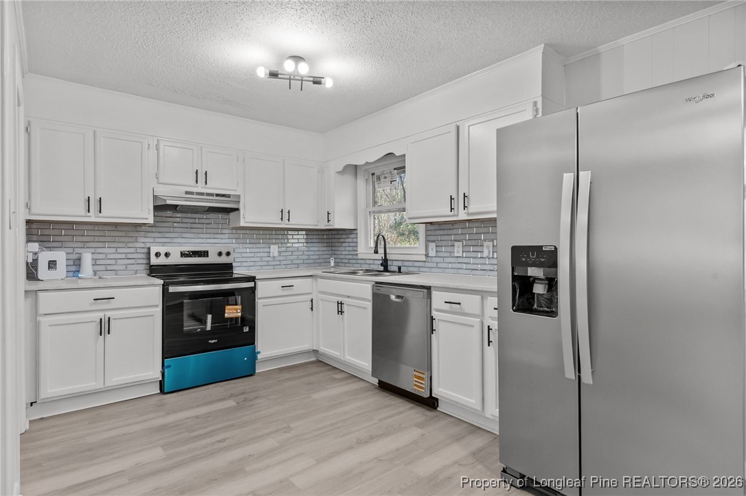 1509 Pope Street Raeford, NC 28376 - Photo 11 of 30 a kitchen with stainless steel appliances granite countertop a refrigerator stove and white cabinets