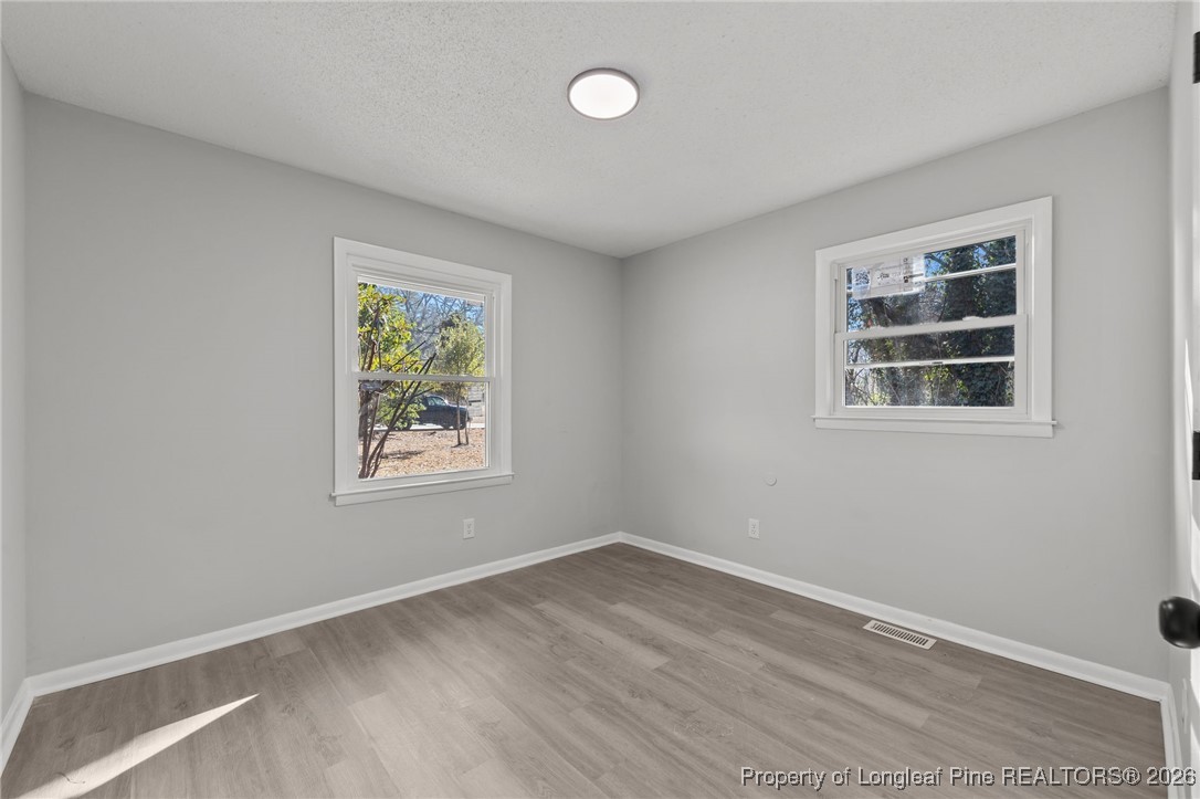 1509 Pope Street Raeford, NC 28376 - Photo 18 of 30 a view of an empty room with a window and wooden floor