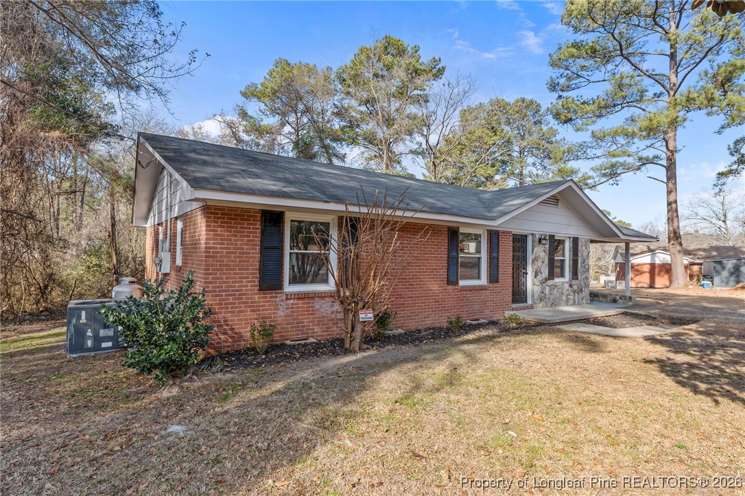 1509 Pope Street Raeford, NC 28376 - Photo 3 of 30 a wooden house with tree in front of it