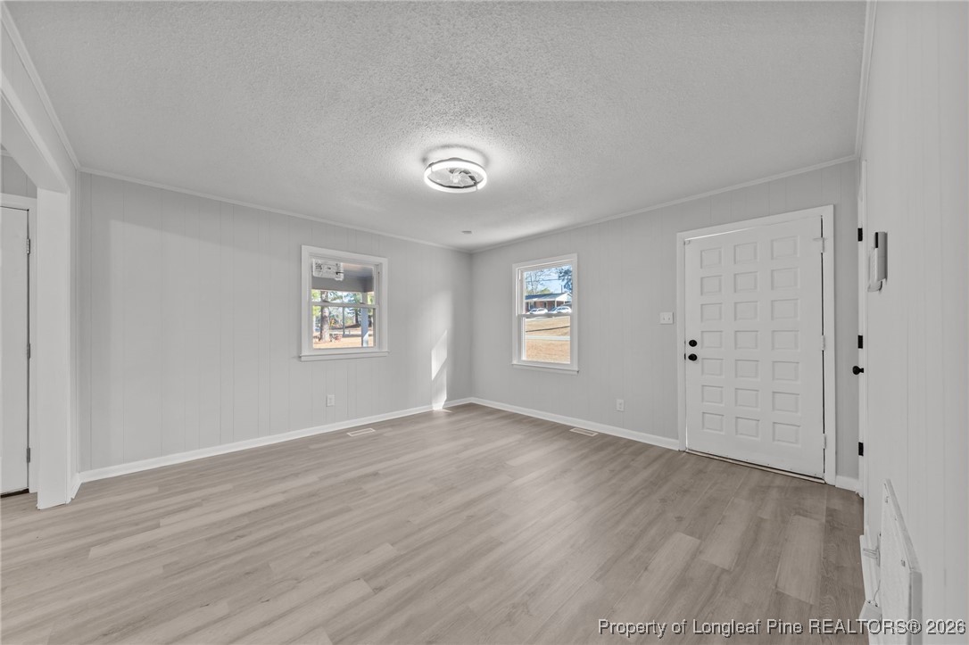 1509 Pope Street Raeford, NC 28376 - Photo 7 of 30 an empty room with wooden floor and windows