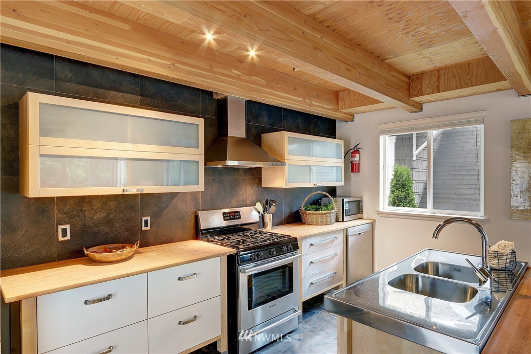 2771 59th Avenue Southwest Seattle, WA 98116 - Photo 6 of 23 a kitchen with a sink cabinets and window