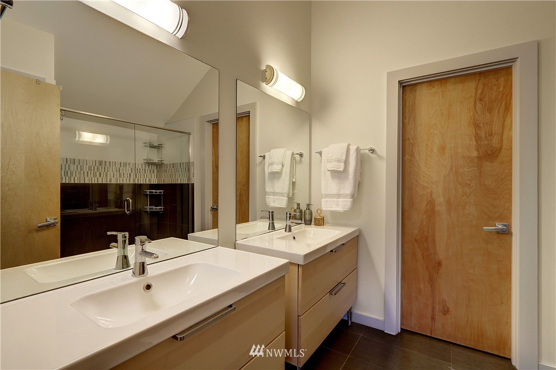 2771 59th Avenue Southwest Seattle, WA 98116 - Photo 10 of 23 a bathroom with a double vanity sink a mirror and shower
