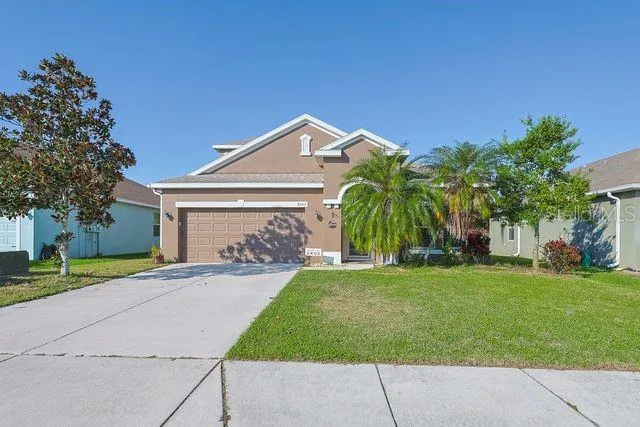 a front view of a house with a yard and trees