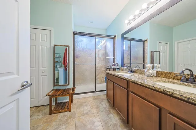 a spacious bathroom with a granite countertop sink and a mirror