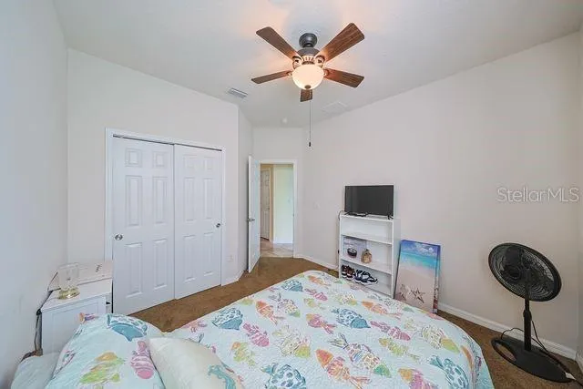 a bedroom with a bed and a flat tv screen on the dresser