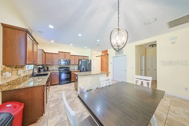 a living room with stainless steel appliances granite countertop furniture and a kitchen view
