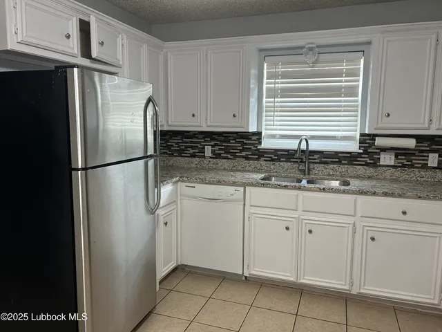 a kitchen with stainless steel appliances granite countertop a refrigerator sink and cabinets